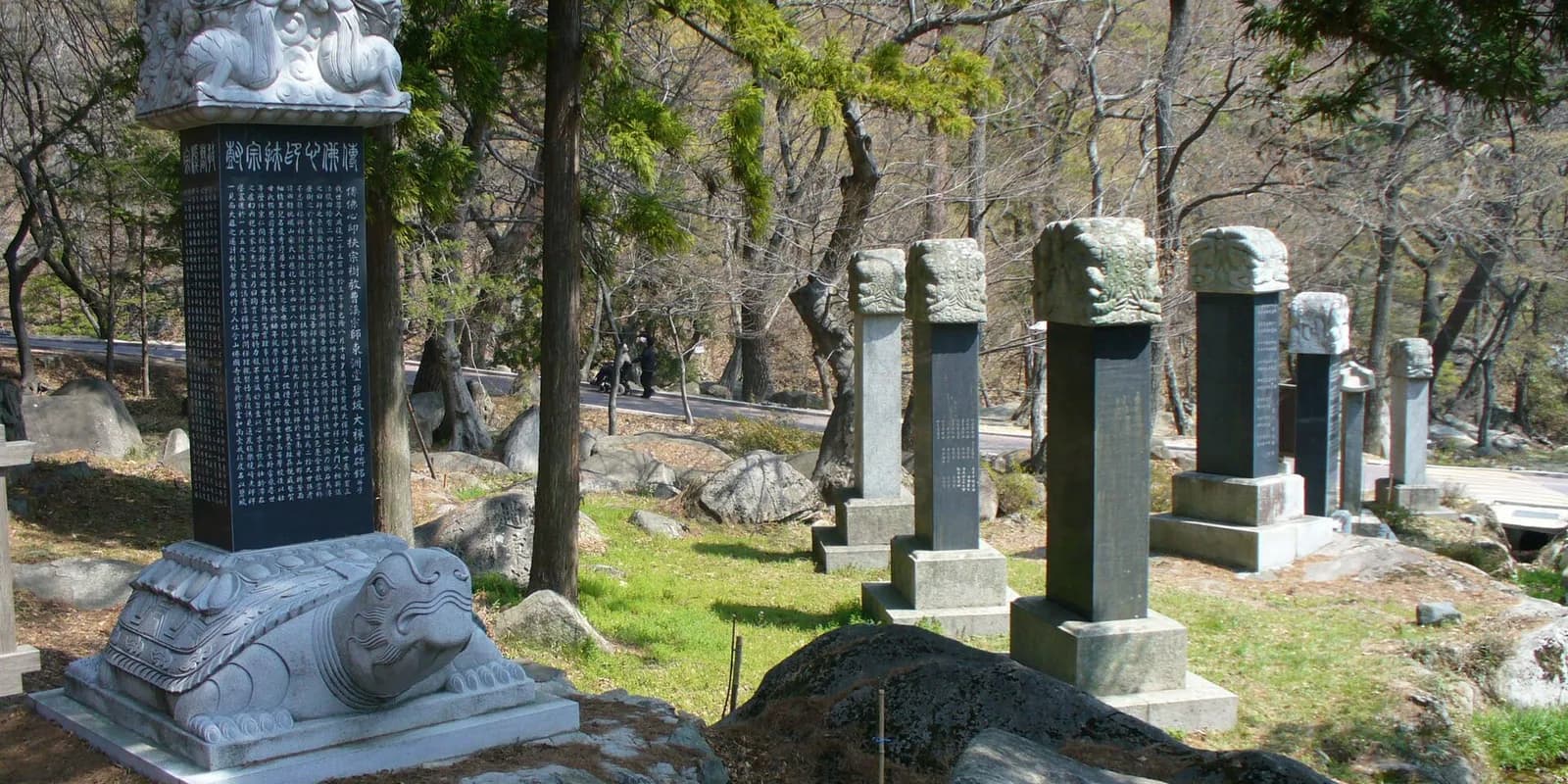 금정산 숲에 둘러싸인 부산 범어사 대웅전과 마당의 삼층석탑 전경