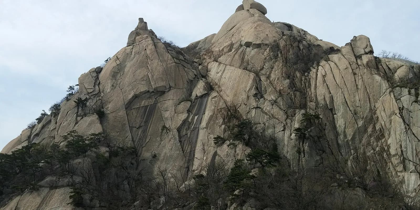 북한산 백운대 정상의 화강암 봉우리와 그 아래로 펼쳐진 서울 시내 전경