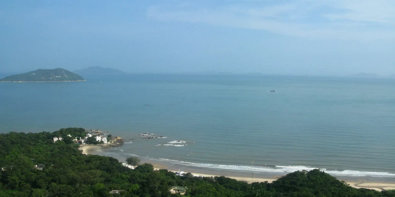 홍콩 란타우섬 청사 해변의 길게 이어진 백사장과 뒤편의 우거진 산 능선