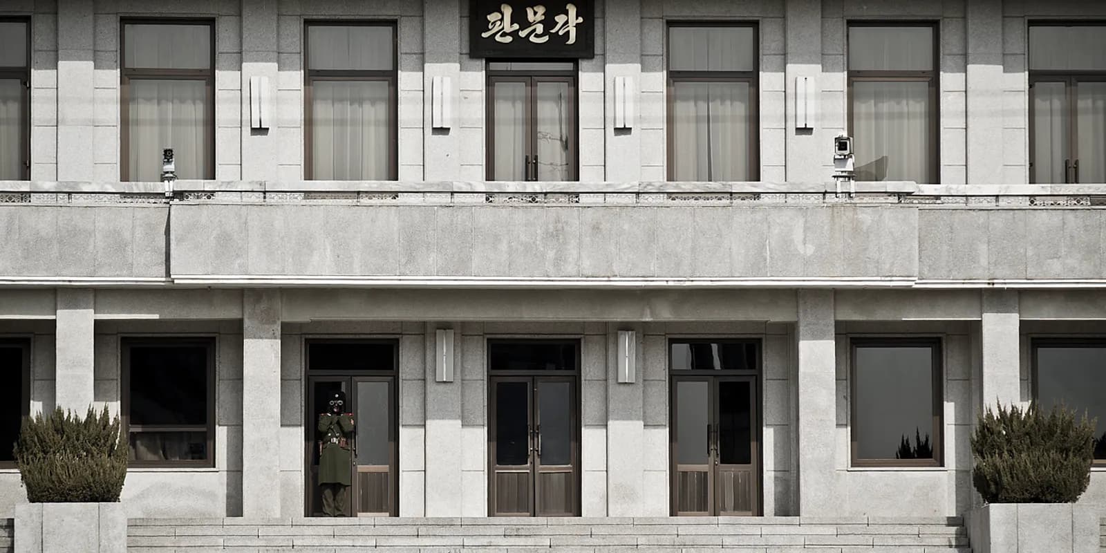 판문점 공동경비구역(JSA)의 하늘색 회담장 건물과 경비병 모습