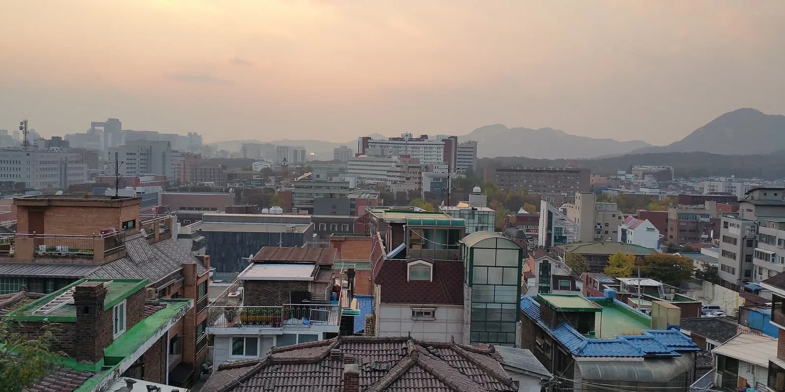 서울 이화벽화마을의 비탈 골목과 담벼락 벽화, 그 위로 이어지는 낙산 성곽길 풍경