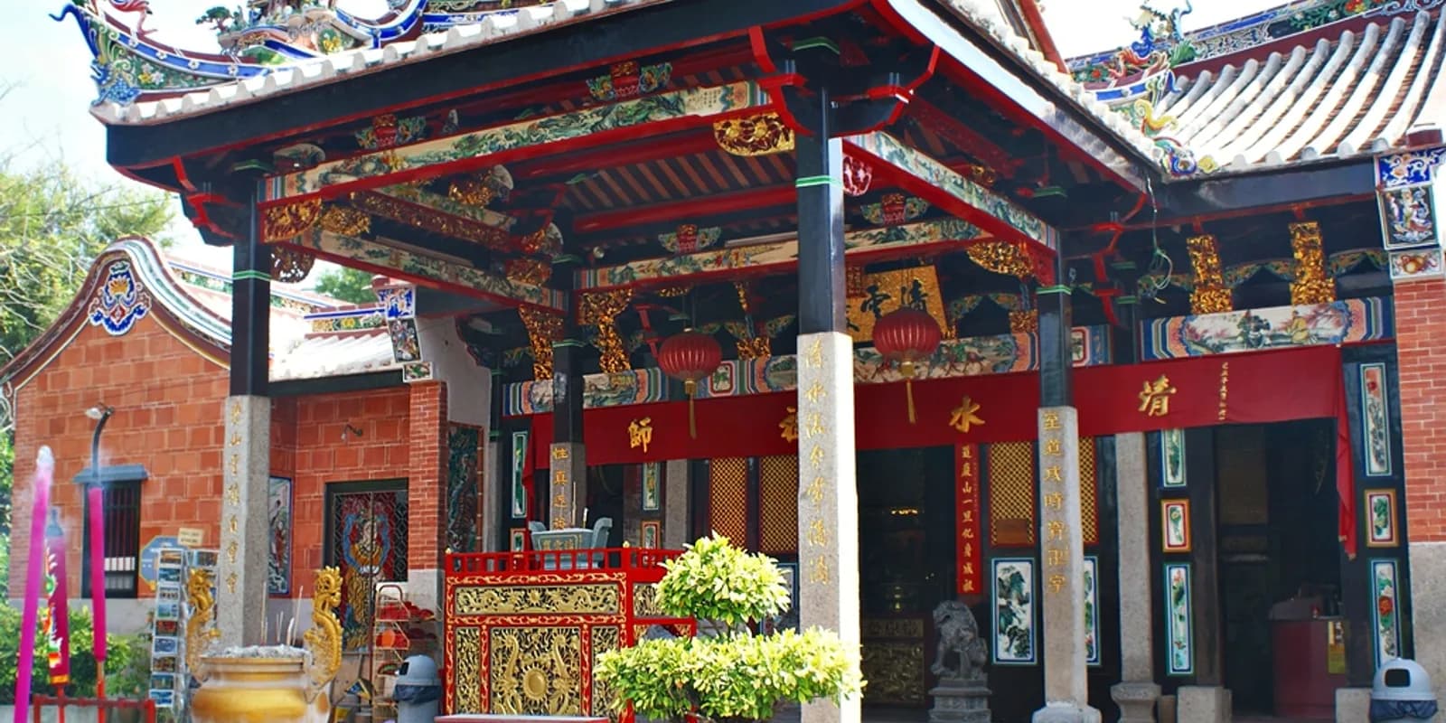 페낭 뱀 사원 본전 제단에 향 연기가 자욱하게 퍼진 가운데 나뭇가지에 초록빛 살무사들이 감겨 있는 모습