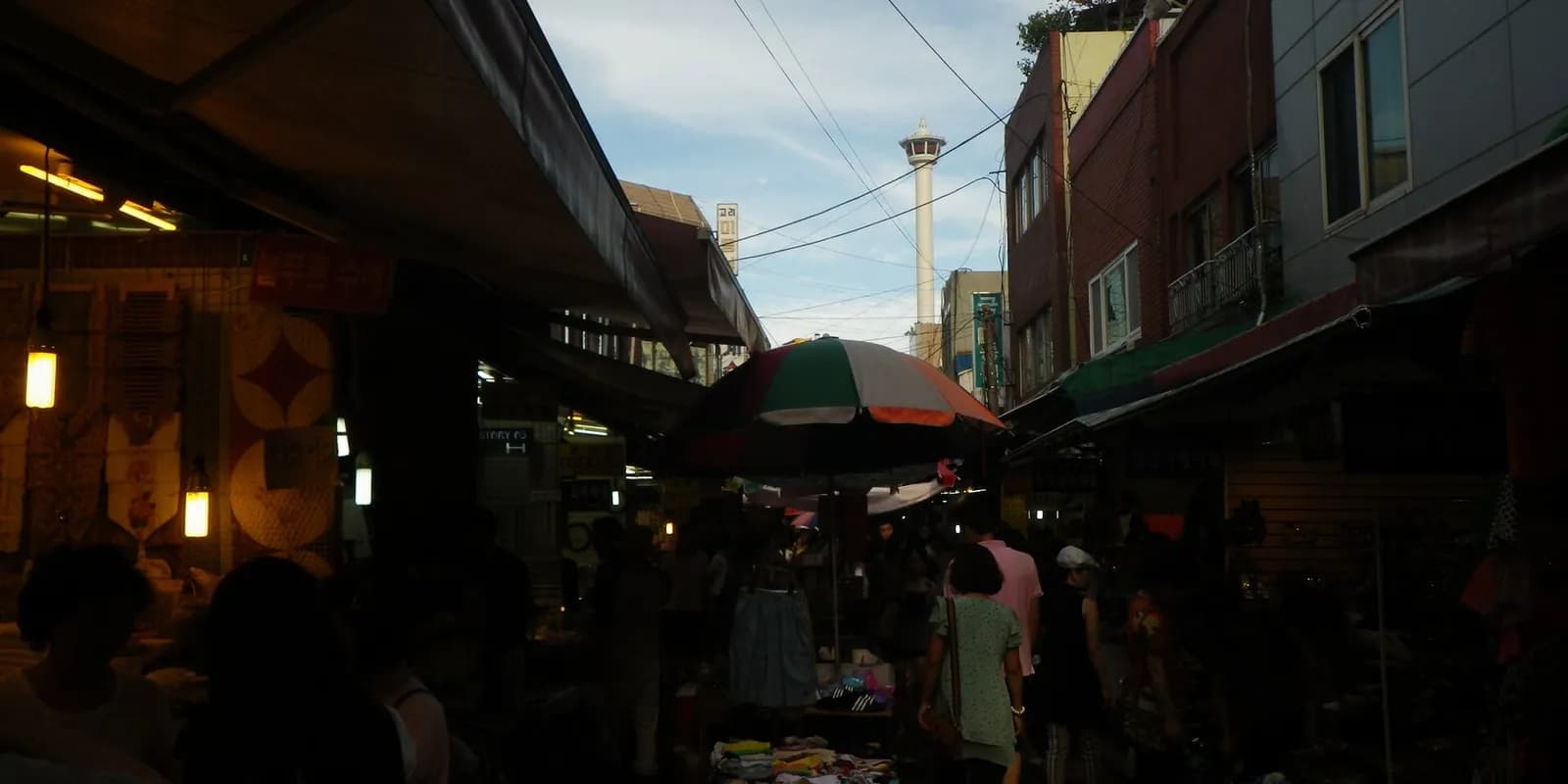 부산 국제시장의 좁은 골목을 따라 상점과 간판이 빼곡히 늘어선 모습