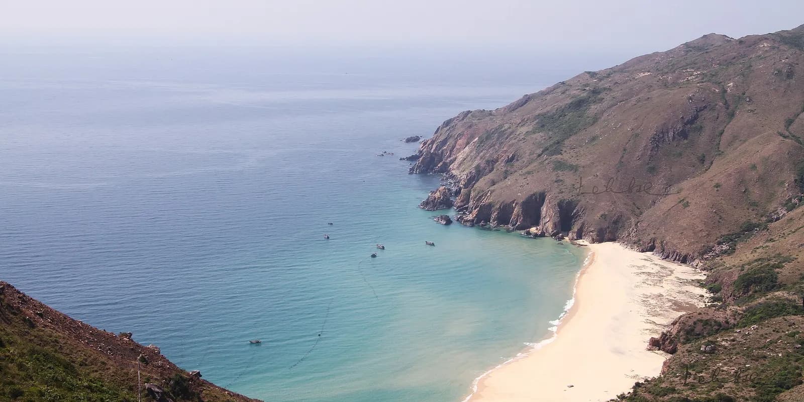 산과 바위로 둘러싸인 반달 모양의 끼꼬 해변과 에메랄드빛 맑은 바닷물