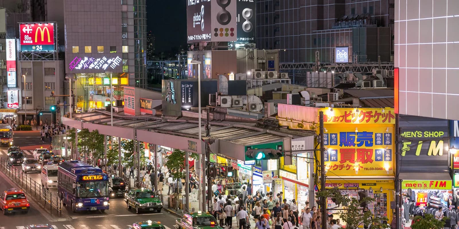 밤에 붉은 등과 초록 네온 간판이 켜진 도쿄 신주쿠 오모이데 요코초의 좁은 골목과 야키토리 가게들