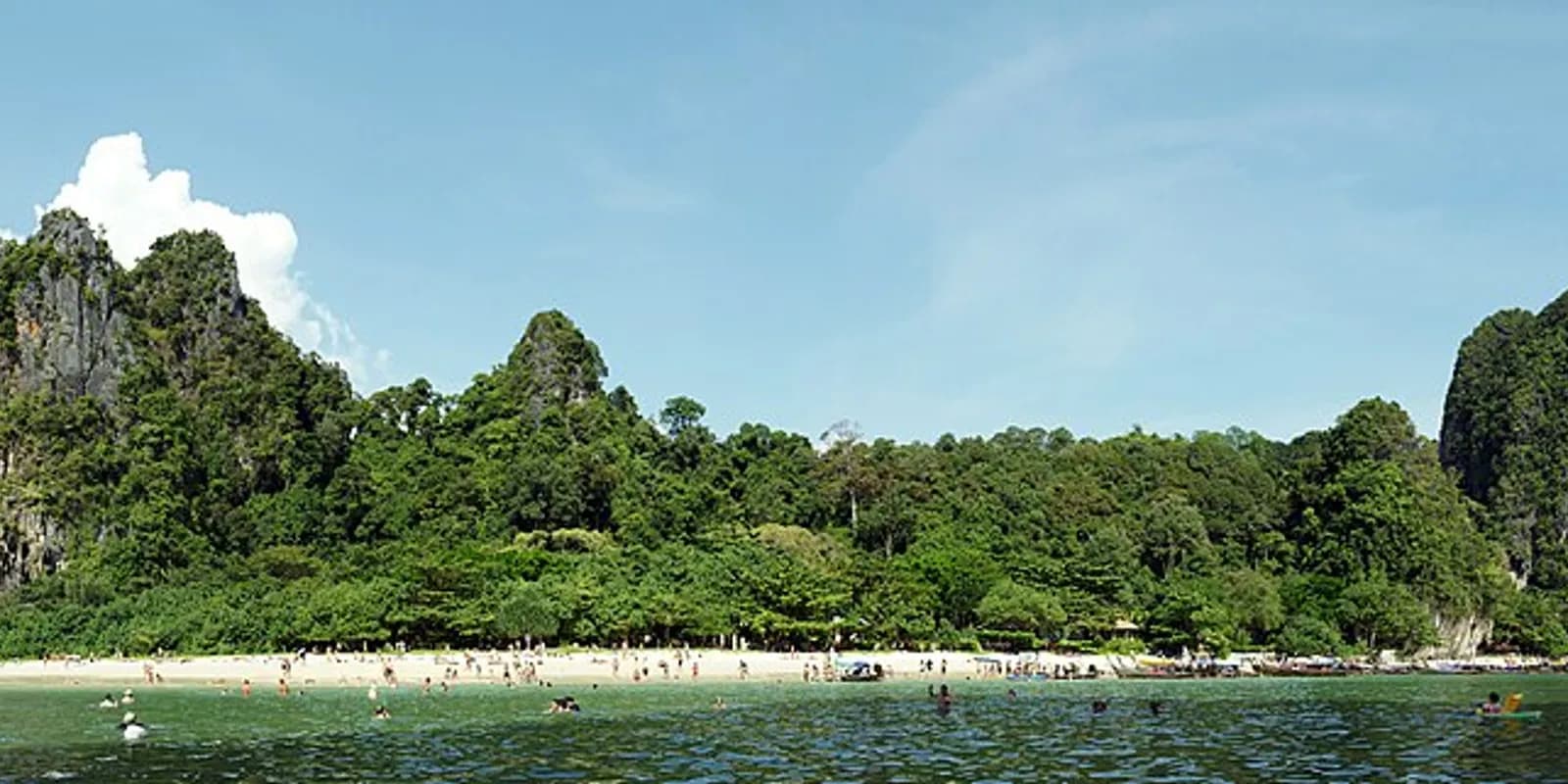 석회암 절벽에 둘러싸인 끄라비 프라낭 케이브 비치의 에메랄드빛 바다와 하얀 모래사장, 해변에 정박한 롱테일 보트