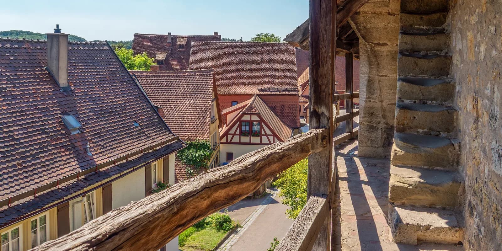 로텐부르크 성벽의 지붕 덮인 목조 회랑에서 내려다본 붉은 기와 지붕과 골목