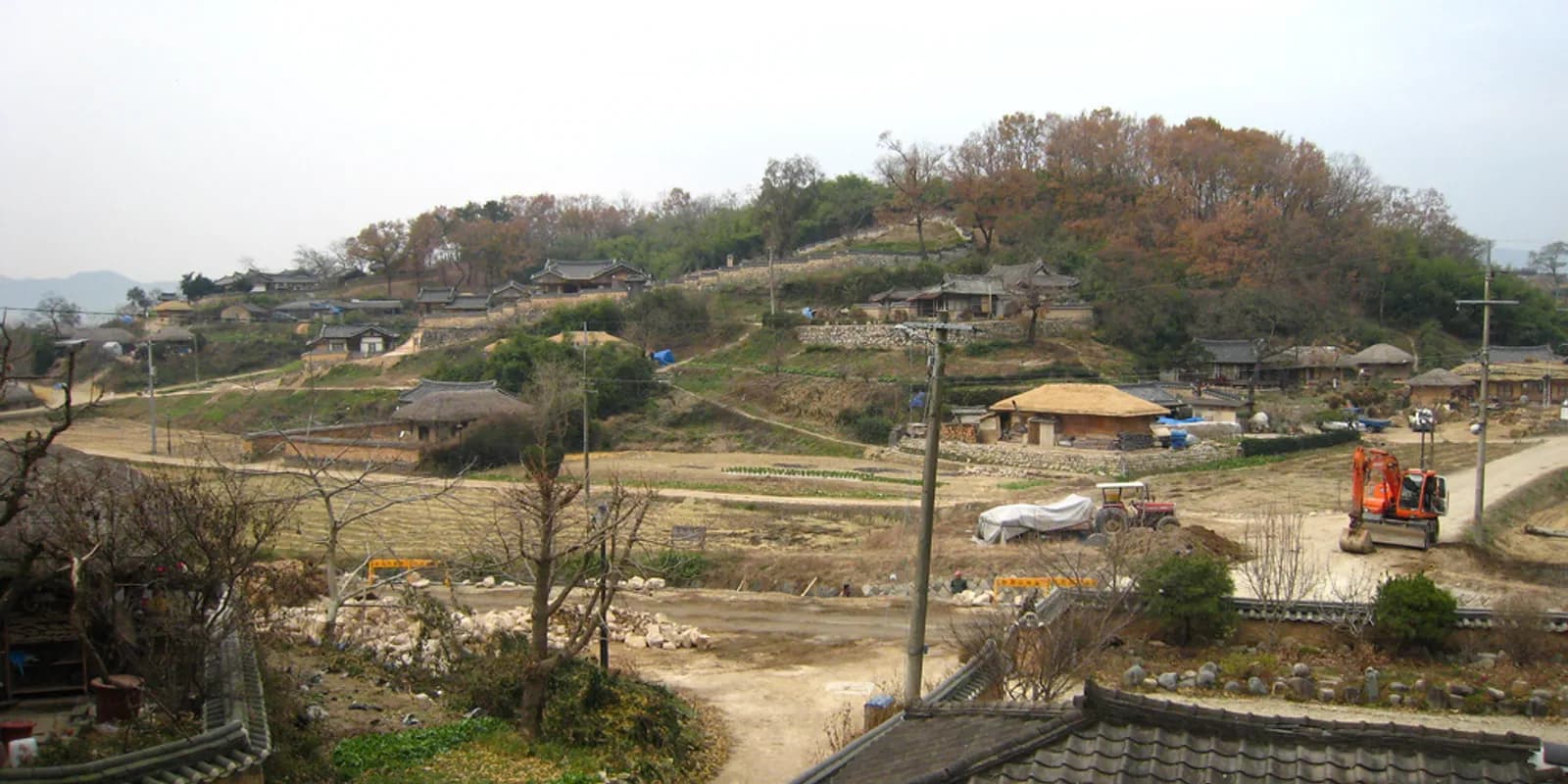 경주 양동마을 산비탈에 자리한 기와집과 초가지붕 고택들, 그 아래로 펼쳐진 논밭 전경